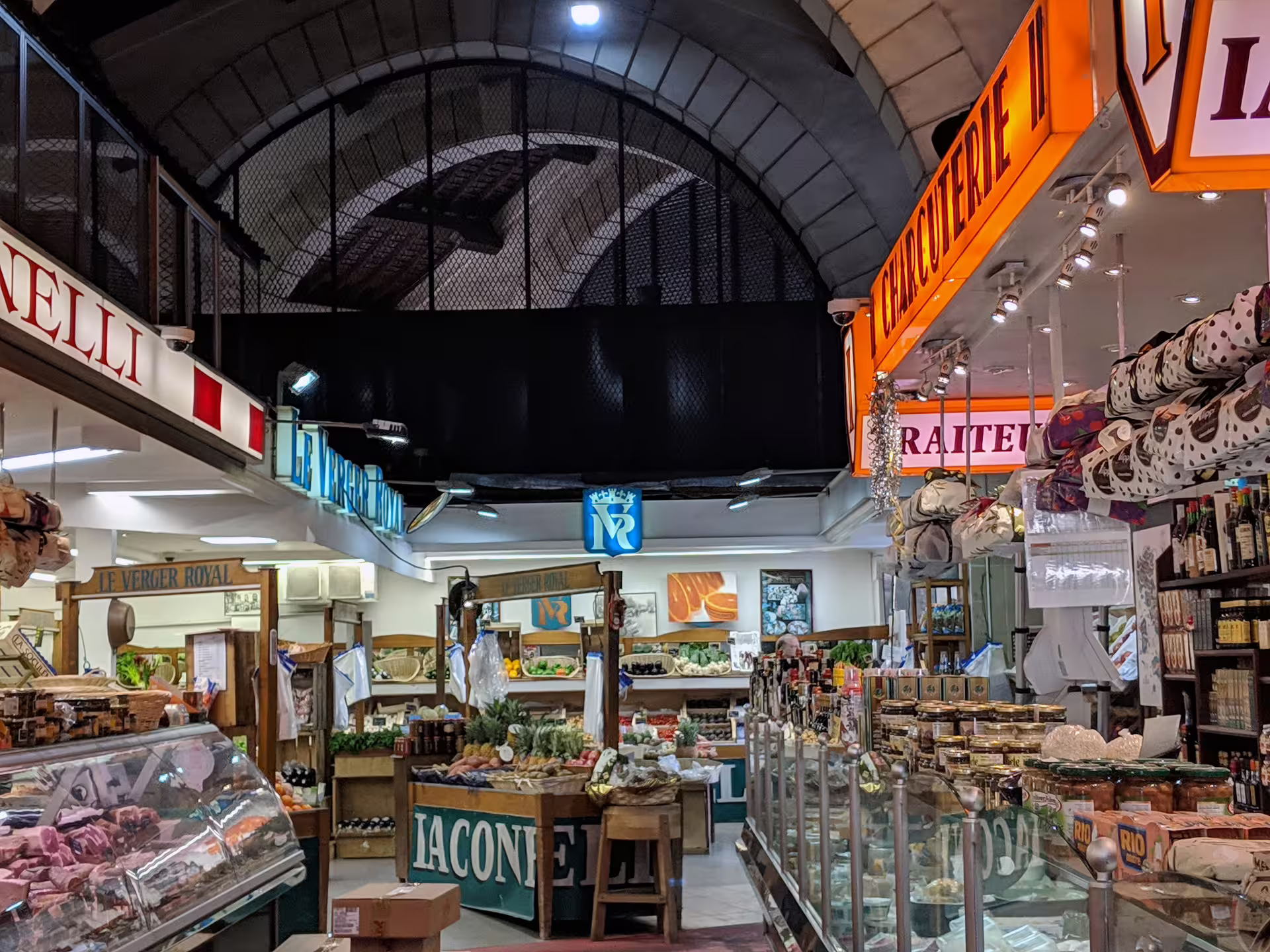 Indoor Versailles market with charcuterie and fresh produce stalls under arched ceiling