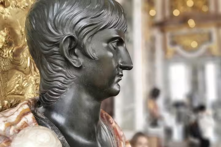 Bronze bust inside Versailles Palace, ornate gilded decor on a private guided day tour from Paris