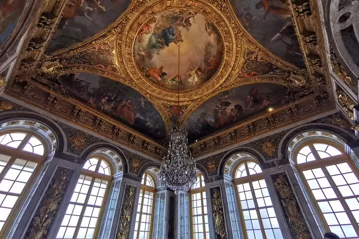 Ornate Versailles Palace ceiling fresco and chandelier on guided tour with skip-the-line tickets