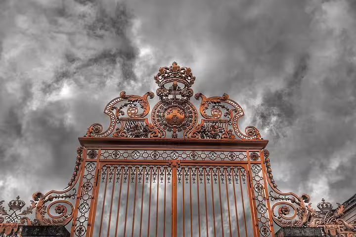 Ornate gilded entrance gate at Palace of Versailles, seen on skip-the-line guided tour in Paris