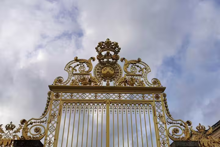 Ornate golden gate at Palace of Versailles entrance on a private full-day guided tour with hotel pickup