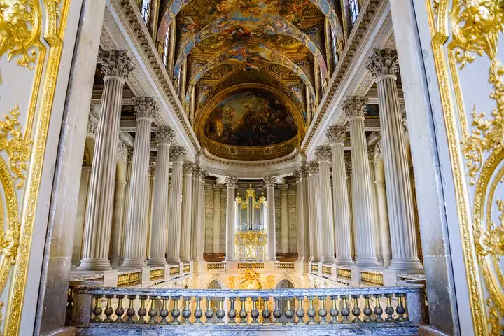 Opulent Versailles palace interior hall with columns and painted ceiling on a guided grand tour visit