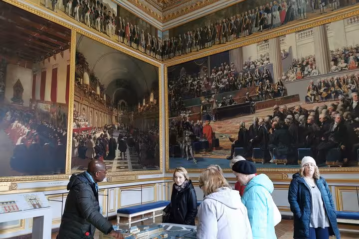 Guided Versailles Palace tour group viewing historic murals in royal gallery, skip-the-line entry included