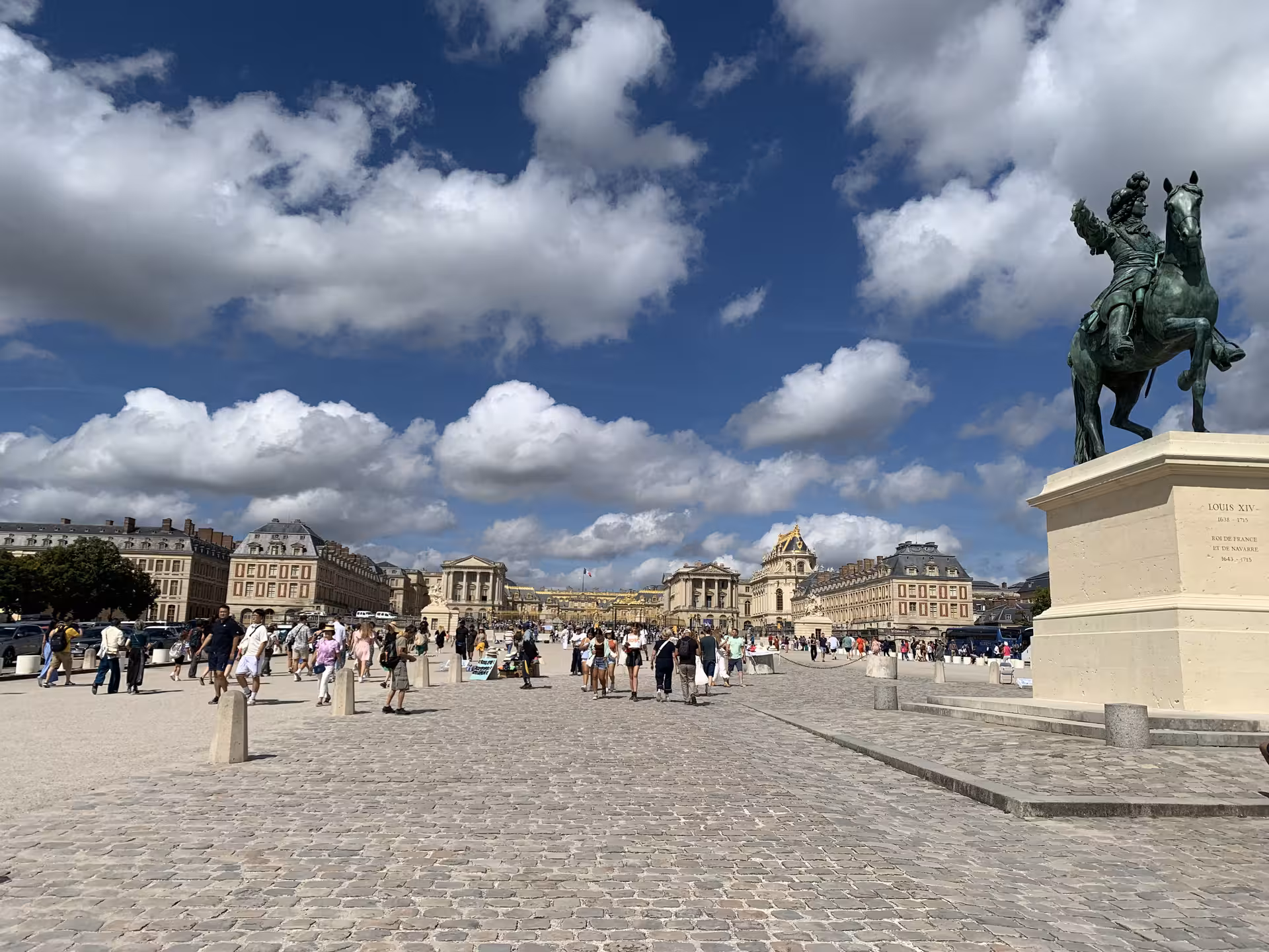 Louis XIV equestrian statue at the entrance courtyard of the Palace of Versailles with tourists