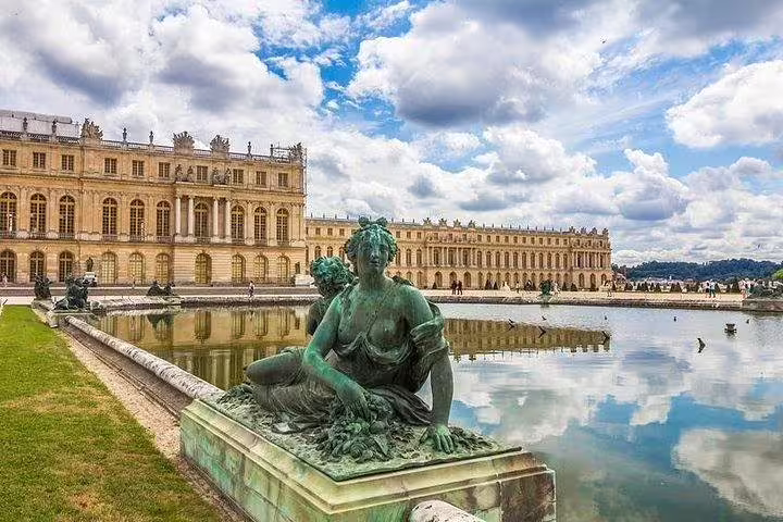 Guests posing by the Versailles Palace Park fountains on a private guided day tour from Paris