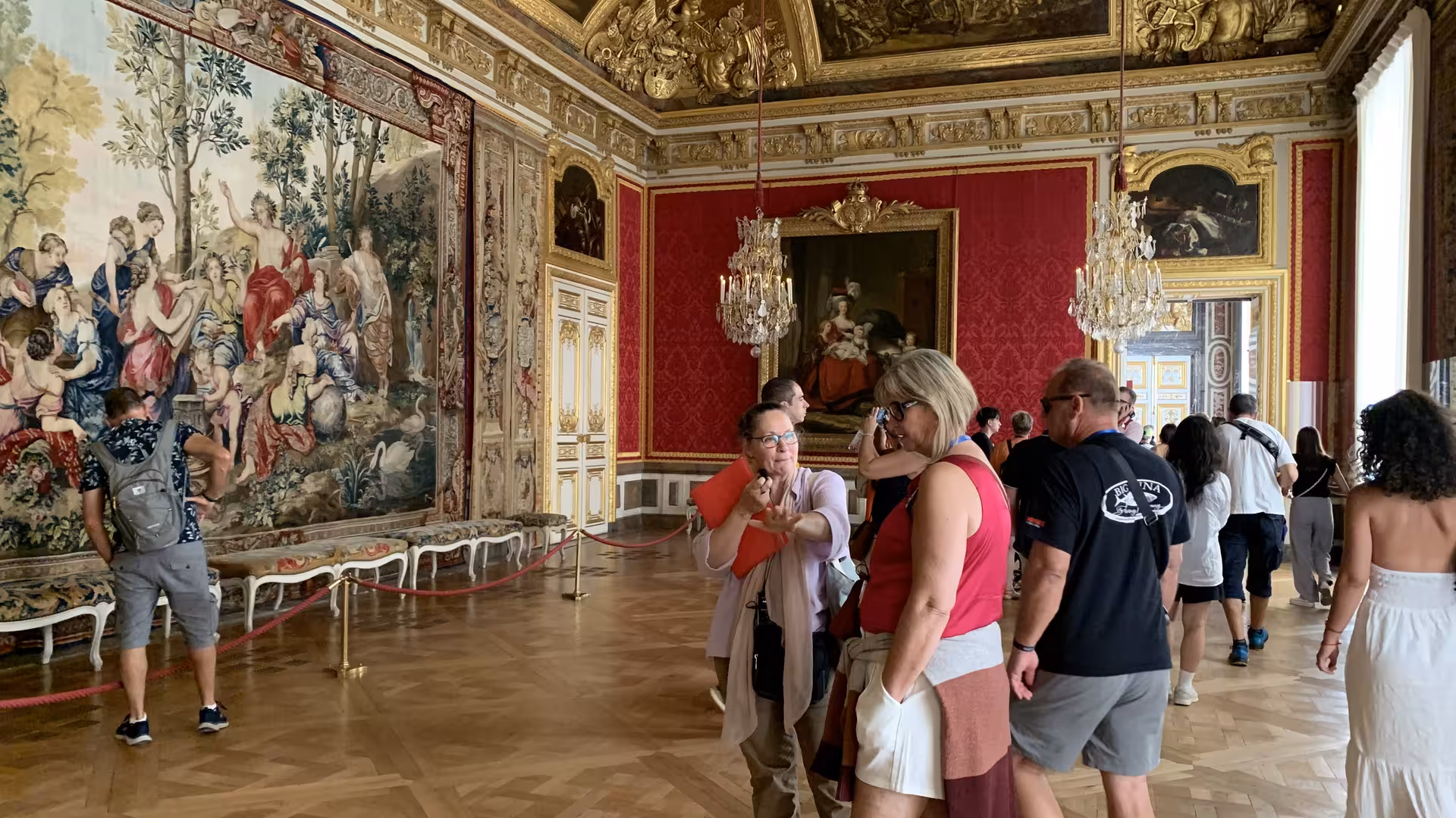Tourists on a private guided tour inside the ornate gilded rooms of the Palace of Versailles
