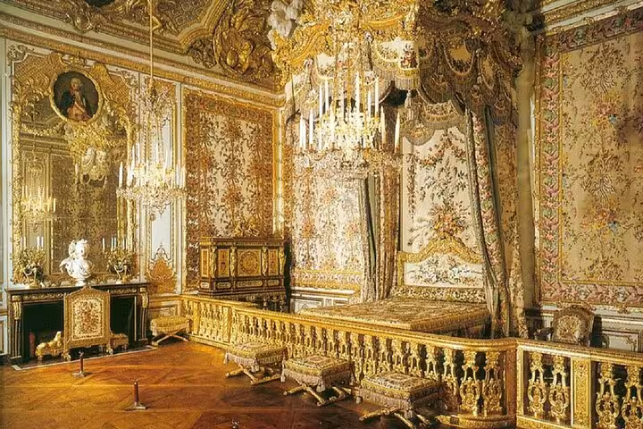 Ornate gilded bedroom of Queen Marie Antoinette with canopied bed at Palace of Versailles