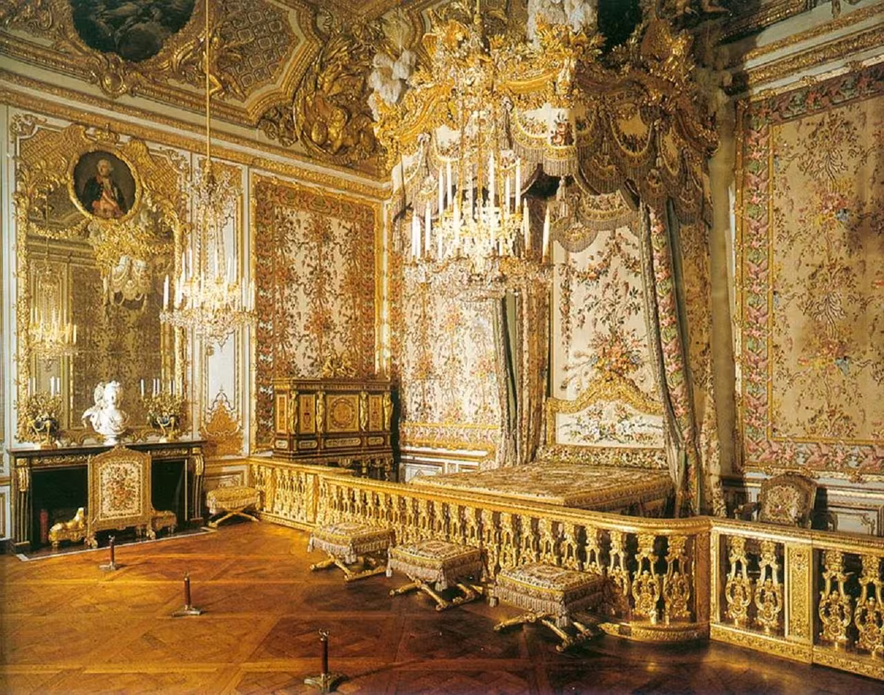 Opulent gilded bedroom of Queen Marie Antoinette with canopied bed and crystal chandeliers at Palace of Versailles