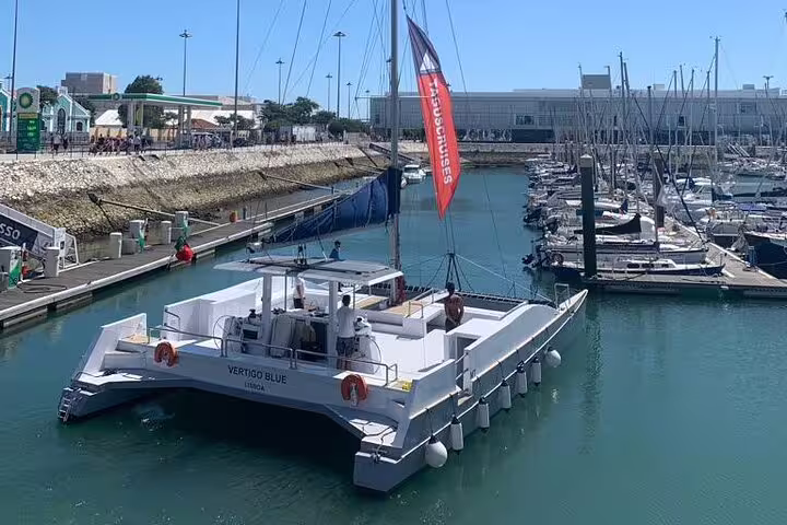 Luxurious catamaran Vertigo docked at Lisbon marina, ready for a private sailing tour accommodating up to 18 guests.