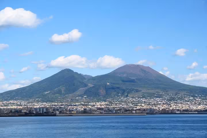 Panoramic view of Mount Vesuvius towering over Naples coastline on a full-day Pompeii and winery tour from Naples.
