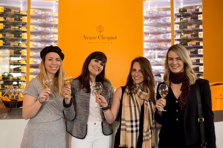 Travelers toast with Veuve Clicquot Champagne in Reims cellar visit on a Champagne tasting day trip from Paris
