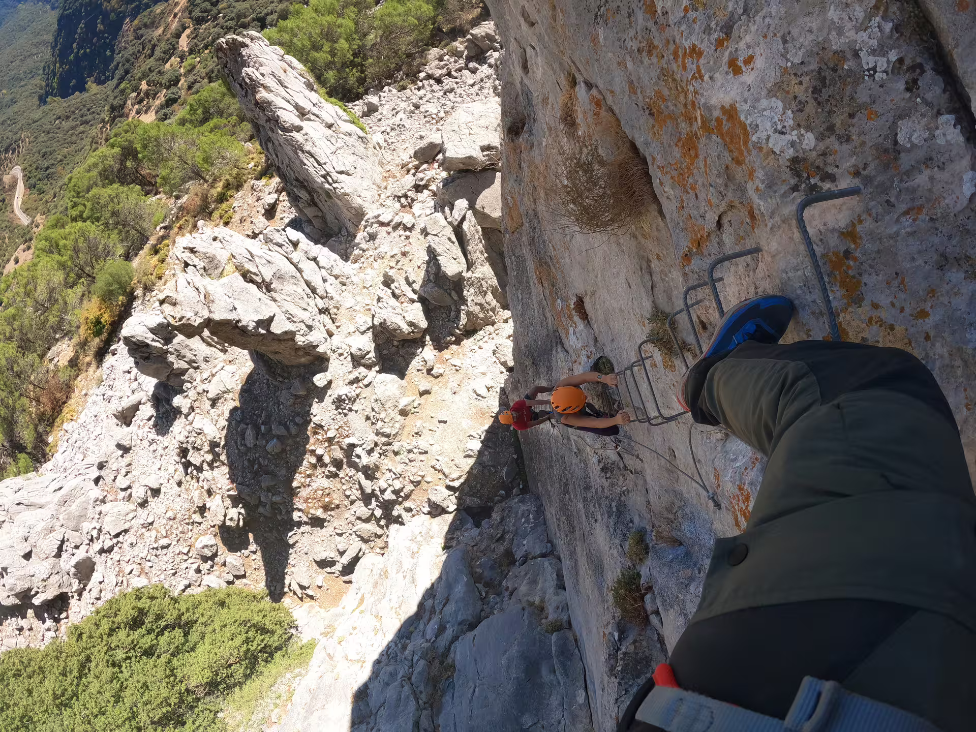 Adventurers climbing Via Ferrata Benadalid, enjoying challenging heights and stunning views of Costa del Sol landscape.