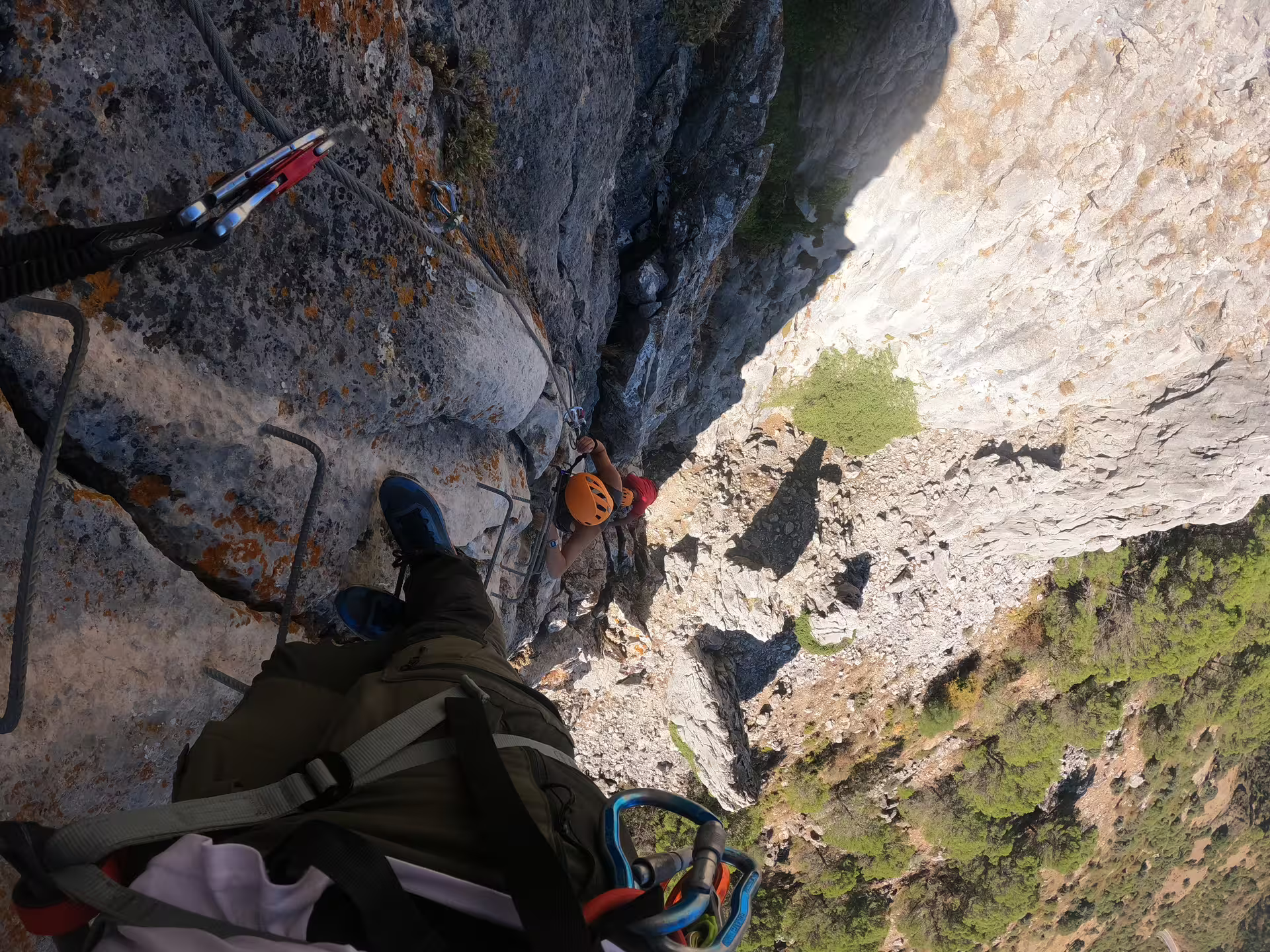 Climber scales a challenging rock wall on Via Ferrata Benadalid, enjoying breathtaking views of Costa del Sol below.