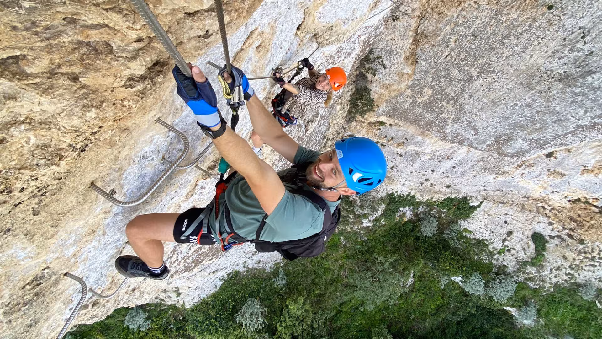 Adventurers climbing Via Ferrata di Giorré in Cargeghe, Sassari, showcasing a thrilling vertical rock ascent.