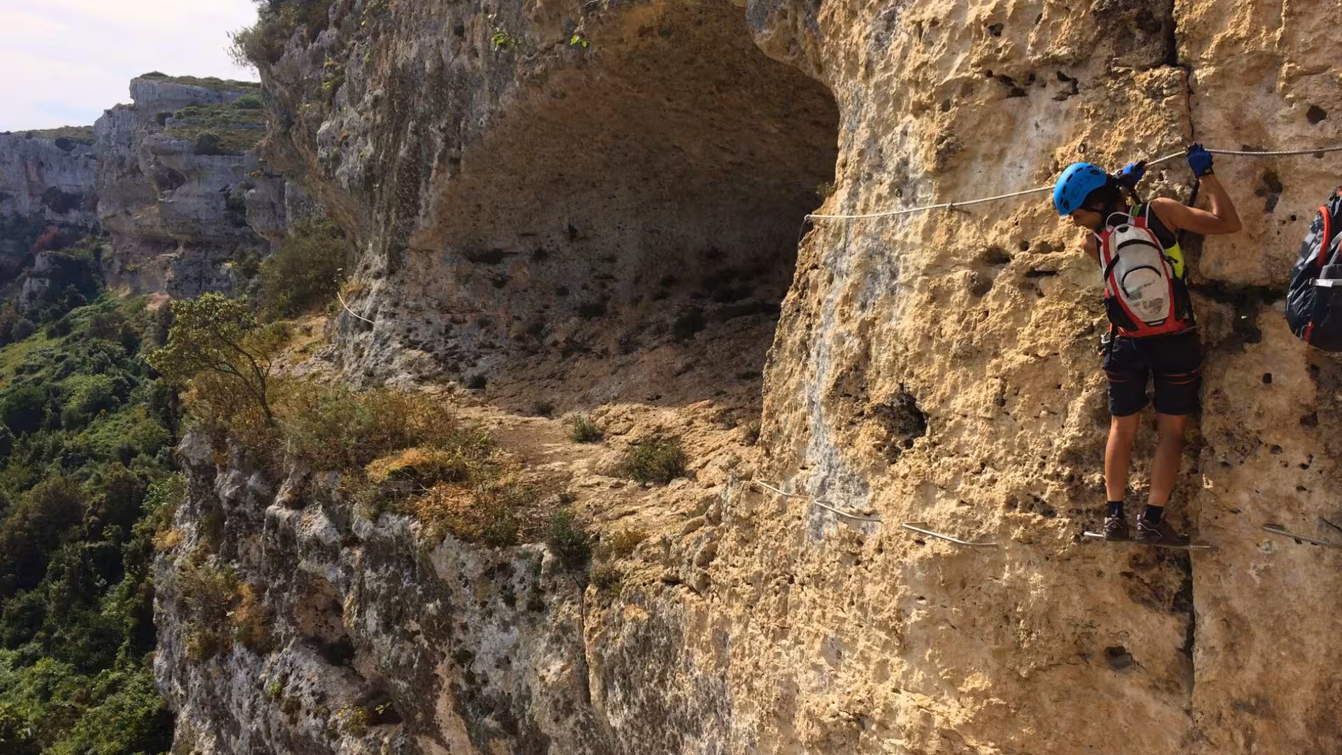 Outdoor enthusiast ascends Via Ferrata di Giorré in Cargeghe, exploring dramatic cliffs and Sardinian scenery.