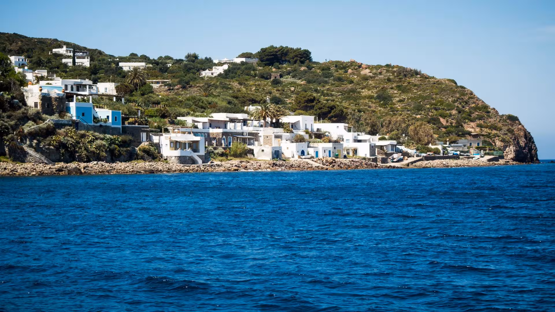 Charming coastal village with whitewashed houses along the azure waters of the Aeolian Islands.