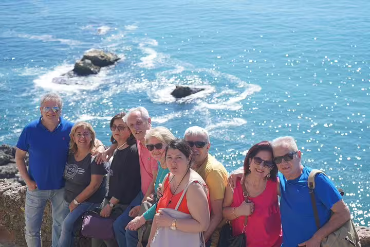 Group of tourists enjoying the scenic ocean view during a guided tour from the Vicentine Coast to Óbidos, Nazaré, and Fatima.