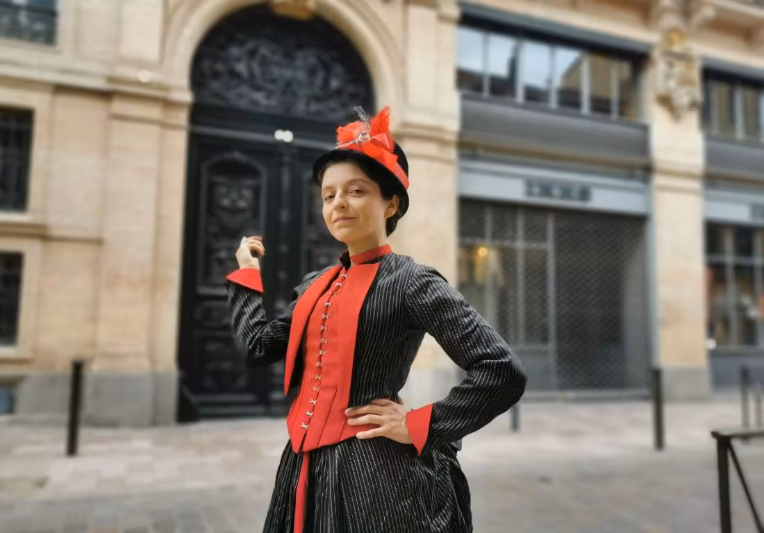 Woman in 19th-century Victorian costume with red corset and hat on Toulouse street