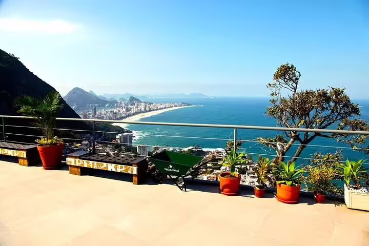 Breathtaking view from Vidigal Favela terrace overlooking Rio's coastline and lush greenery on a sunny day.