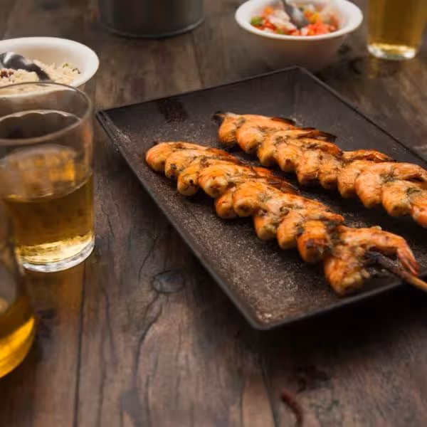 Grilled shrimp skewers and local dishes served during Vidigal Favela walking tour culinary experience.