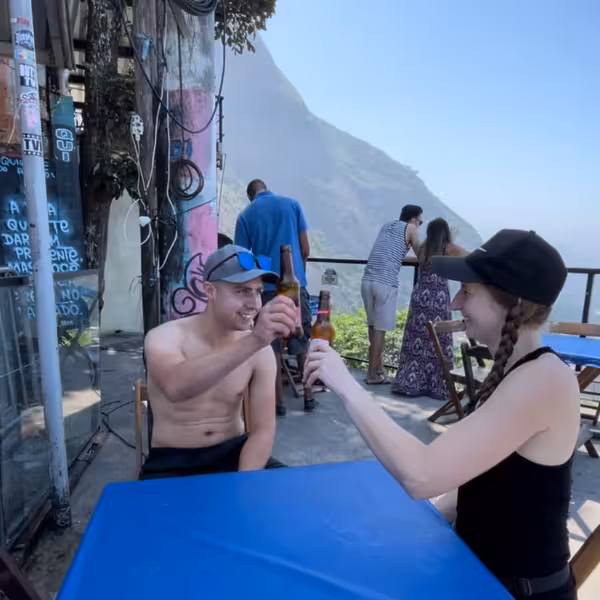Tourists enjoying drinks with stunning Vidigal views on a private walking tour with a local resident guide.