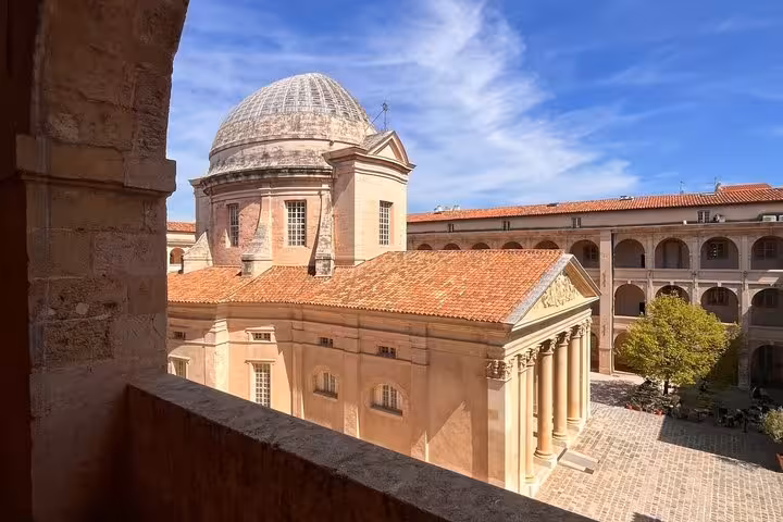 Courtyard and dome of Vieille Charité in Marseille's Le Panier district under blue sky