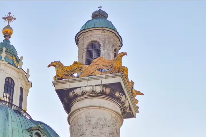 Golden eagle sculptures atop ornate baroque column with domed tower, Vienna
