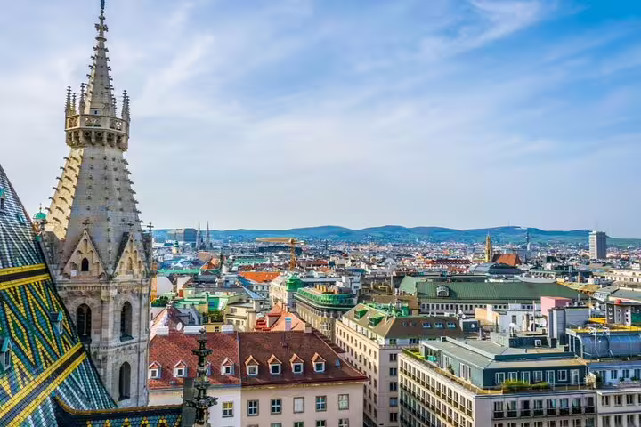 Aerial view of Vienna cityscape with St. Stephen's Cathedral Gothic spire and colorful tiled roof
