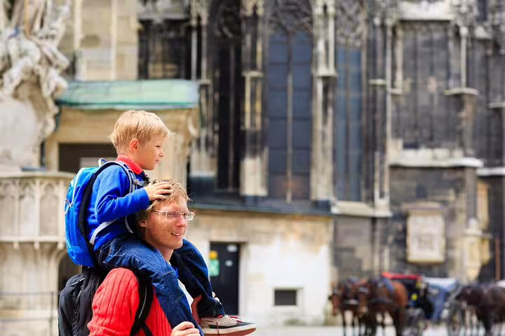 Father and child enjoying Vienna family tour with historic architecture backdrop, featuring city highlights and cultural experiences.