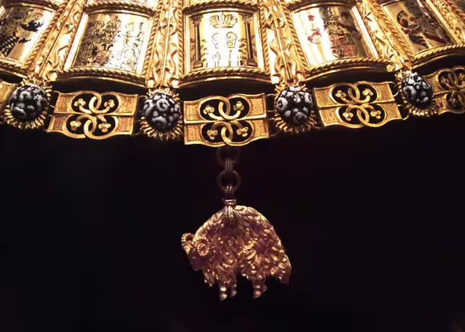 Exquisite gold and jewel-encrusted artifact with intricate designs featured at the Vienna Imperial Treasury.
