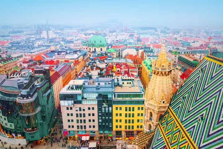 Aerial view of Vienna city center with St. Stephen's Cathedral colorful tiled roof and green domed church