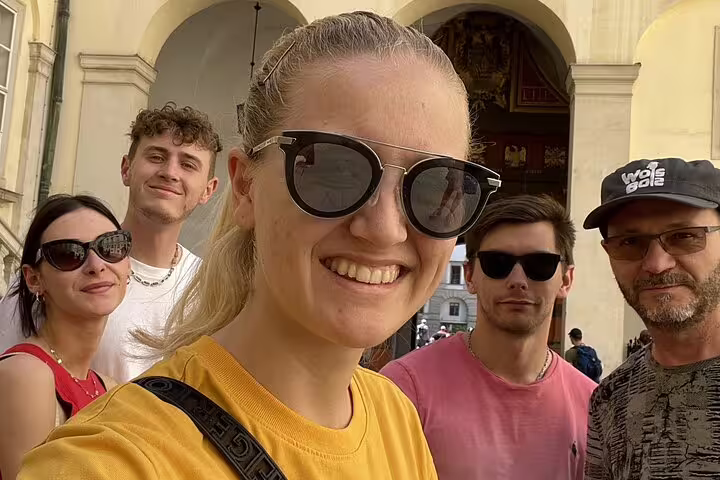 Group of five tourists smiling during a self-guided walking tour in Vienna city center