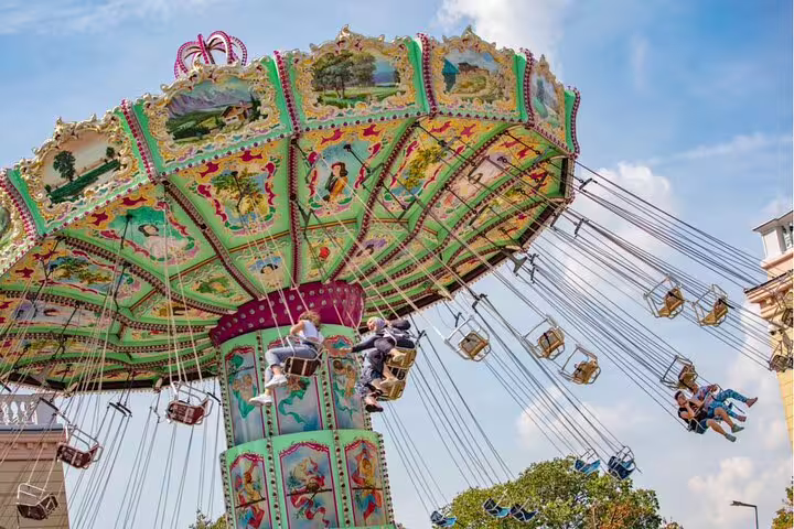 Colorful chain swing carousel ride at Vienna Wurstelprater amusement park with riders soaring through the air