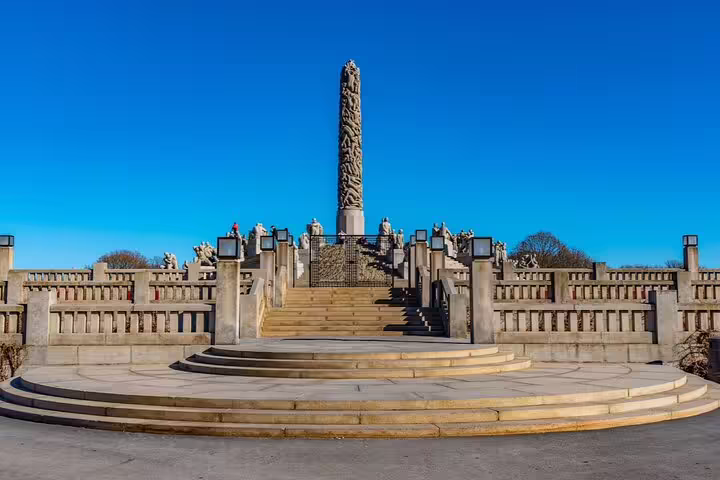 Vigeland Park Monolith sculpture column with stone staircase and statues under clear blue sky, Oslo