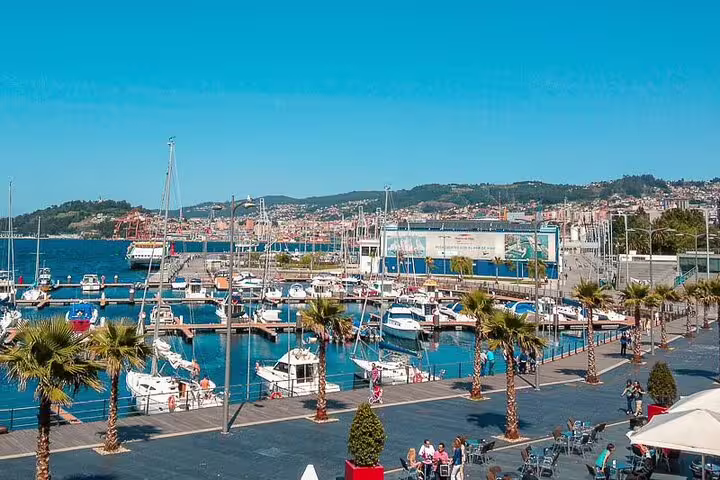 Sunny marina in Vigo with moored boats, a charming stopover on the Porto to Santiago Compostela travel itinerary.