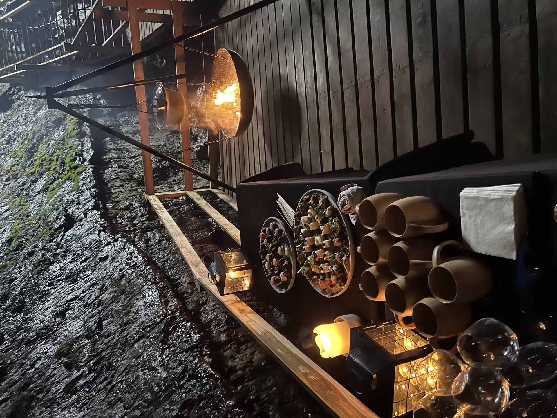 Viking feast cave dining experience in Southeast Iceland with rustic food platters and glowing fire ambiance