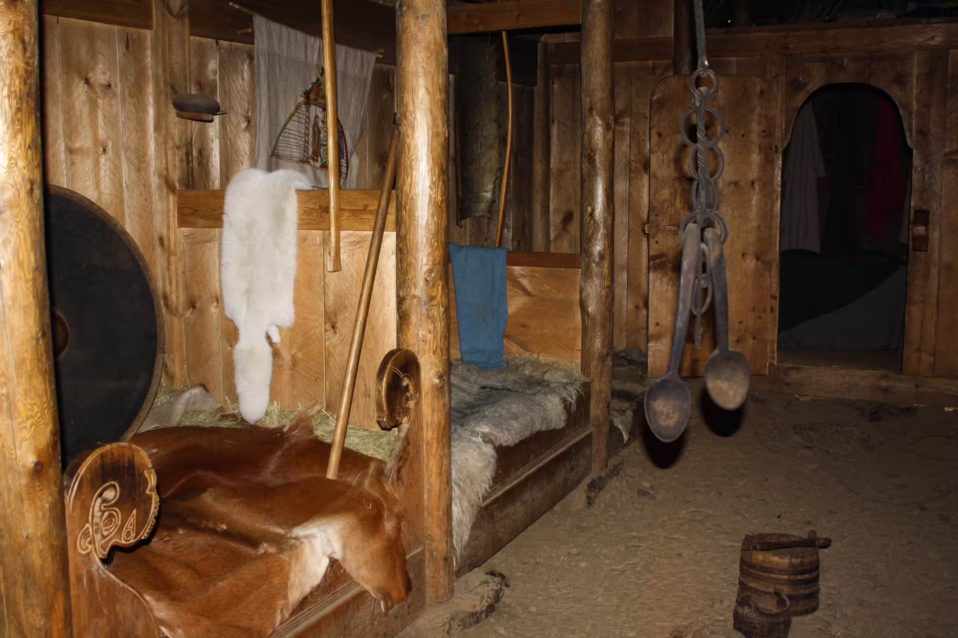 Authentic reconstructed Viking longhouse interior with fur pelts and wooden artifacts explored on Icelandic witchcraft history tour