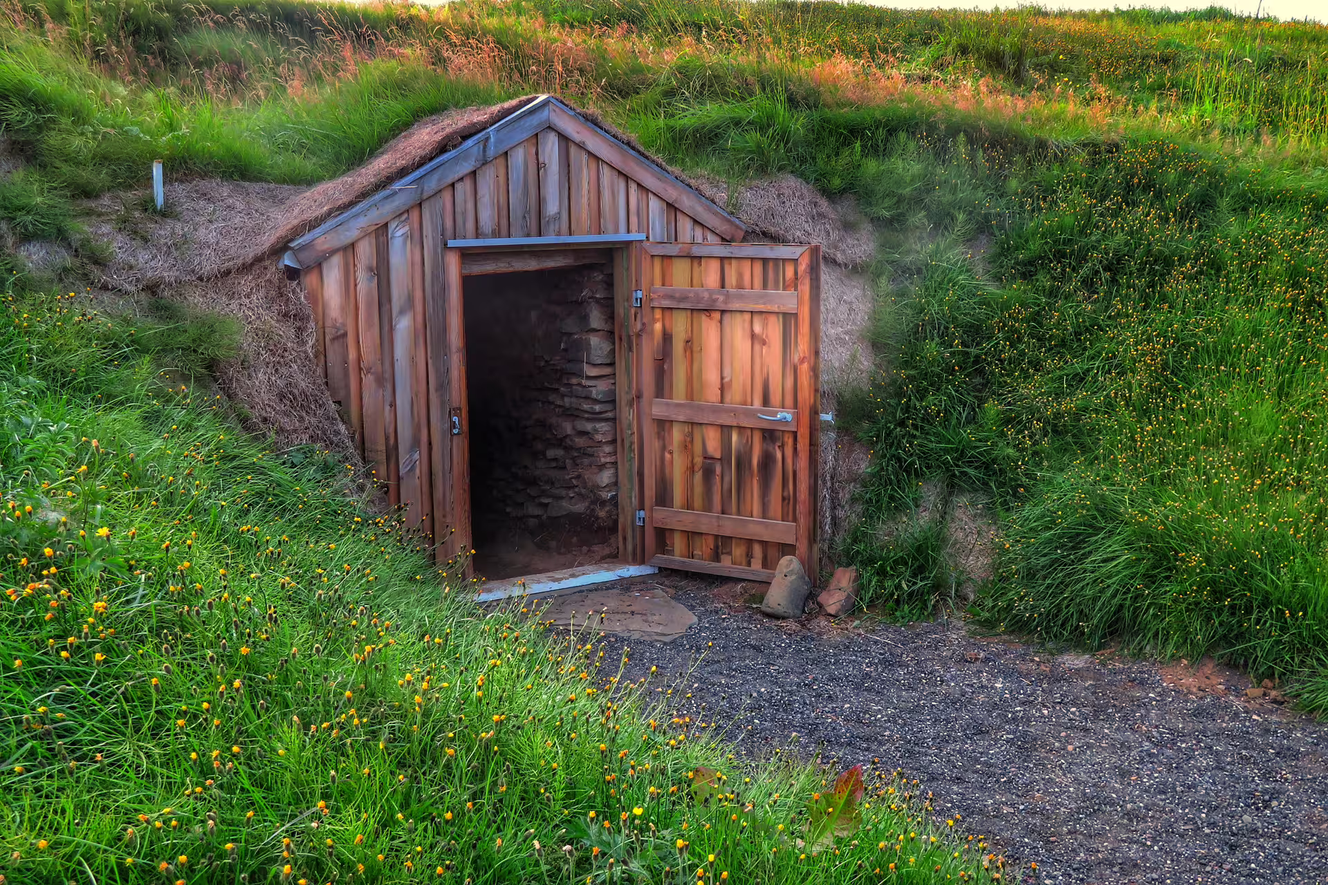 Ancient Viking turf house with wooden door nestled into a green hillside on a Celtic heritage tour