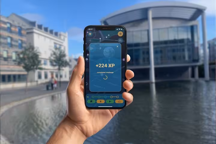 Hand holding smartphone displaying +224 XP challenge completion screen on a self-guided walking tour app
