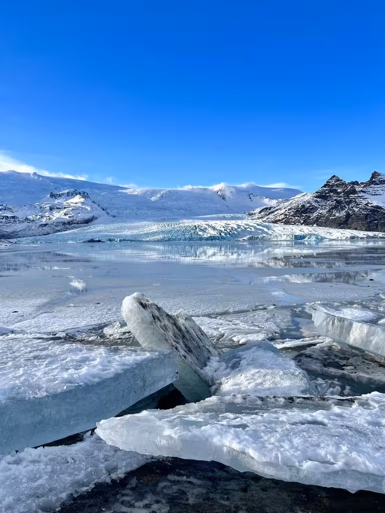 Stunning icy landscape with glaciers and snow-capped mountains under a clear blue sky on a Viking winter adventure.