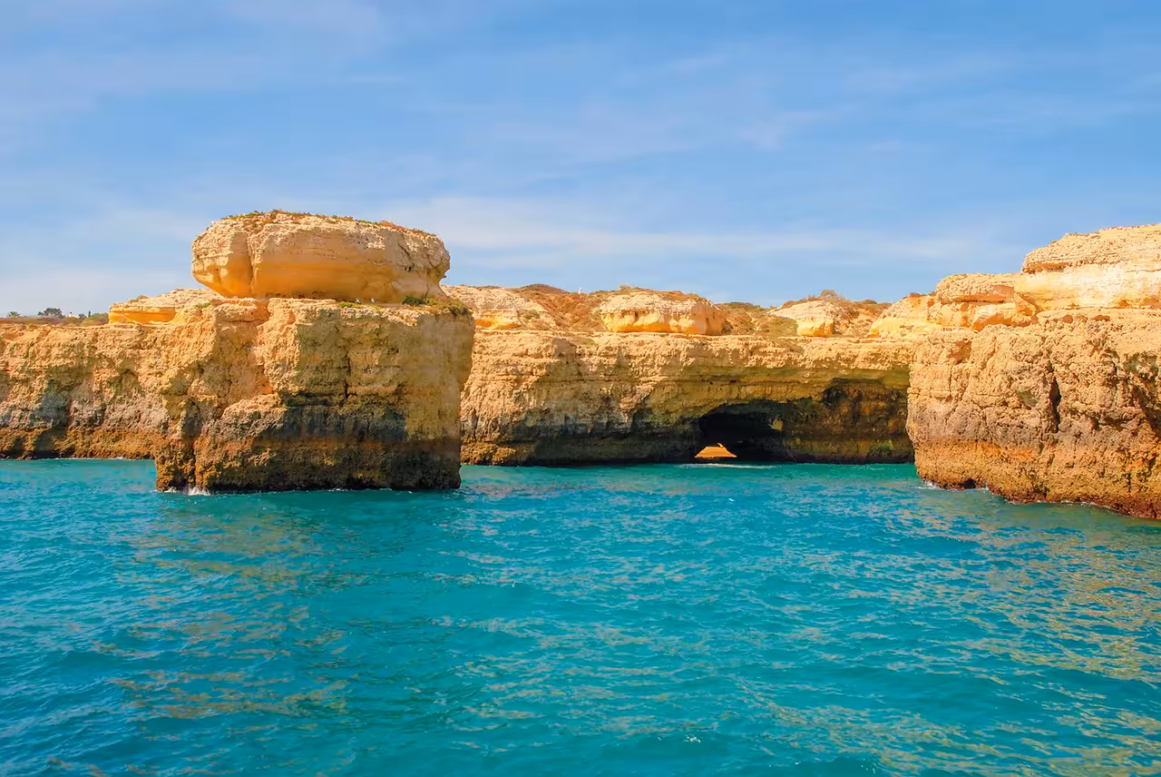 Stunning Algarve golden limestone cliffs and turquoise sea viewed from a Vilamoura catamaran cruise