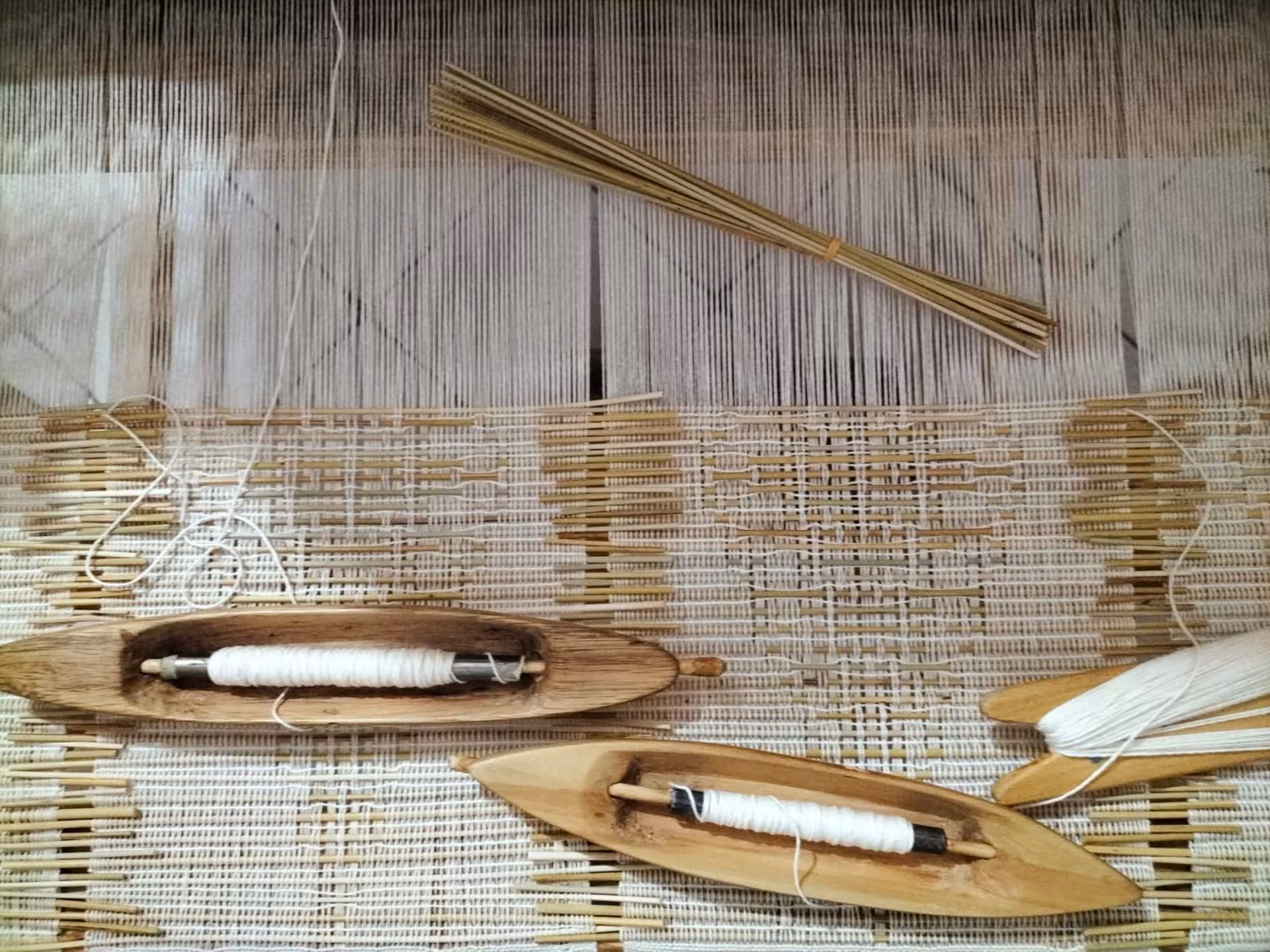 Close-up of weaving tools and threads on a loom at Villacidro workshop, showcasing traditional Sardinian techniques.