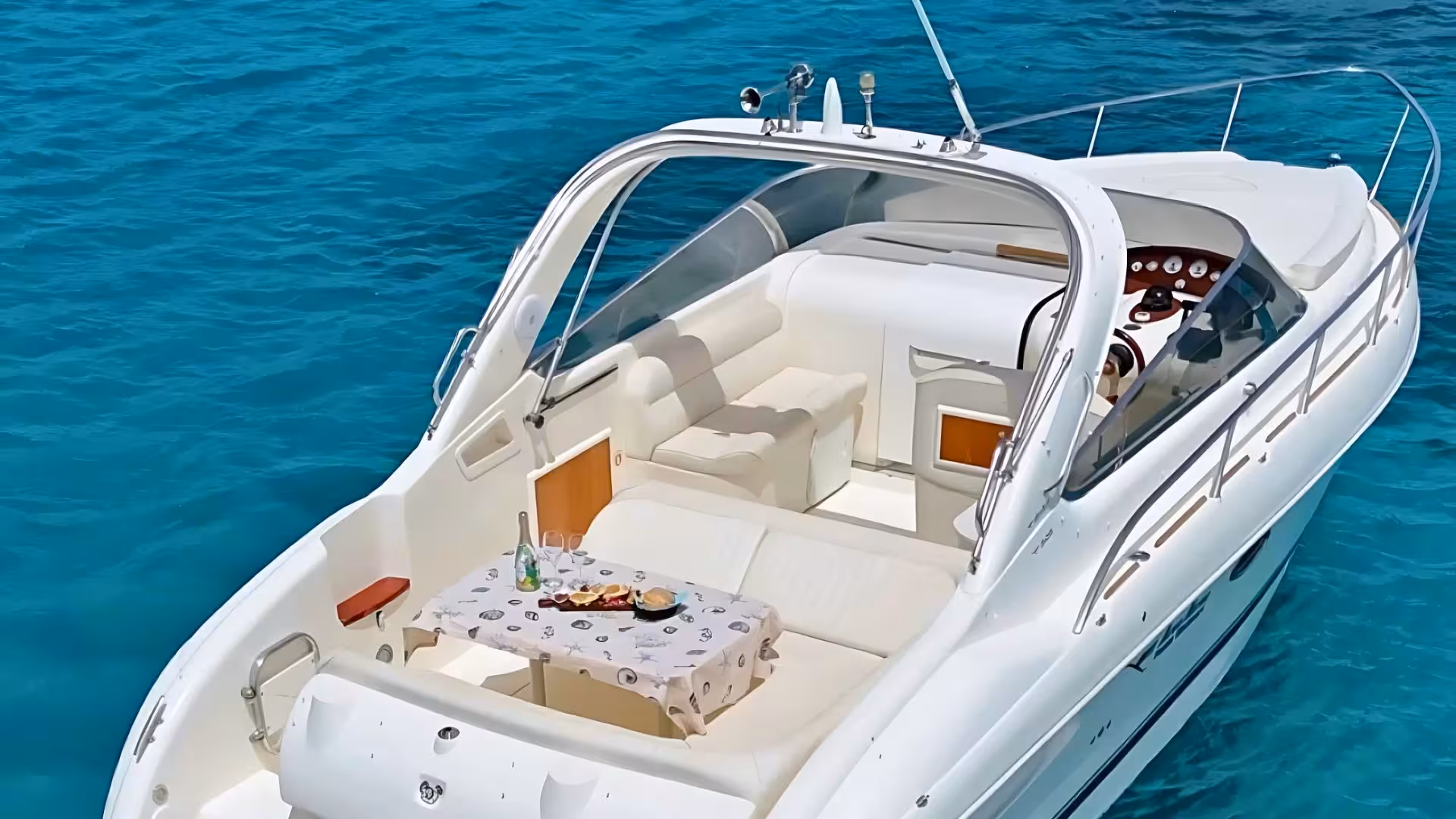 Luxurious speedboat with cozy seating and refreshments on clear blue waters in Villasimius private tour.