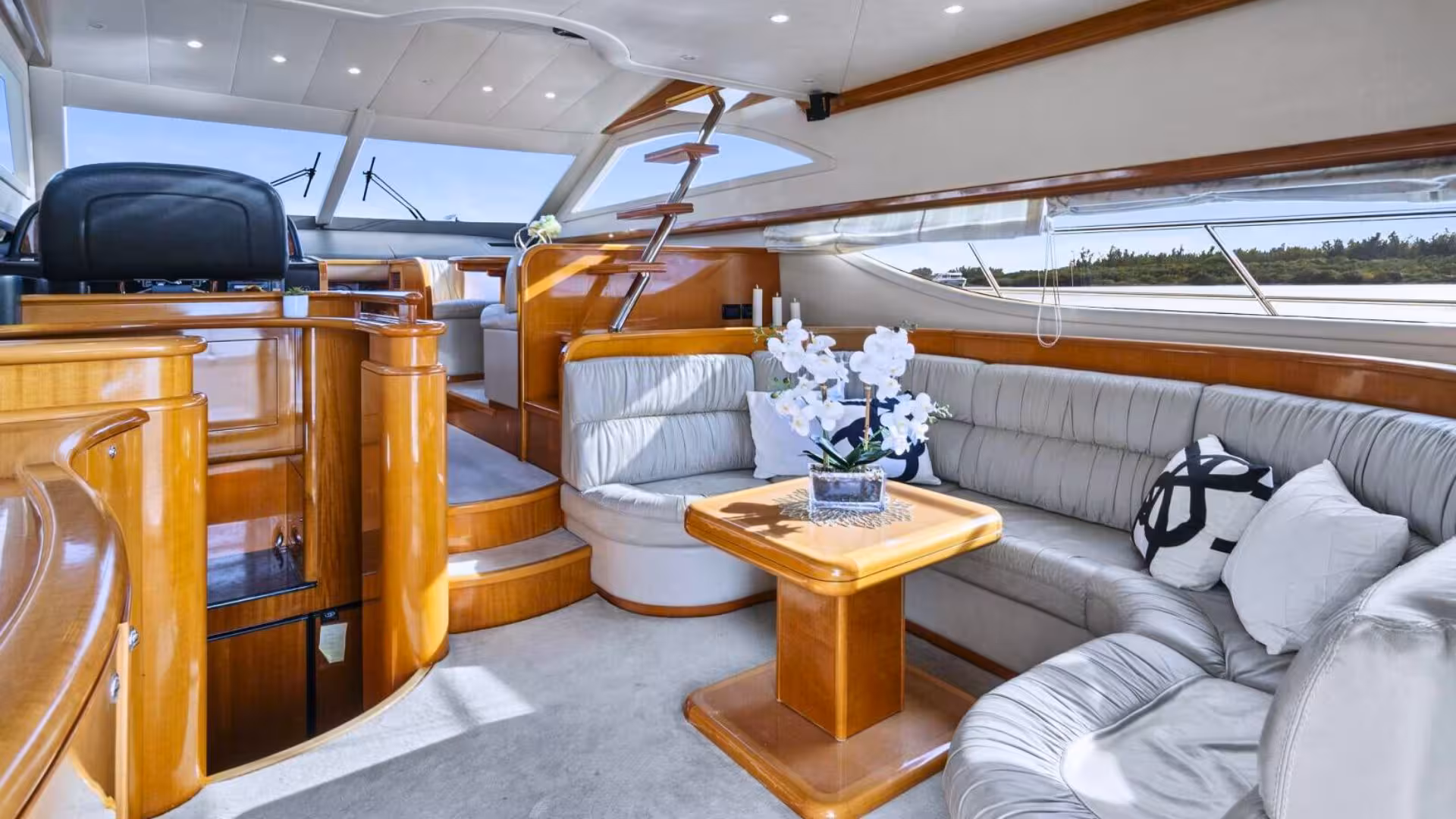 Elegant interior of a yacht with plush seating and wooden accents, offering comfort and style on Villasimius tours.