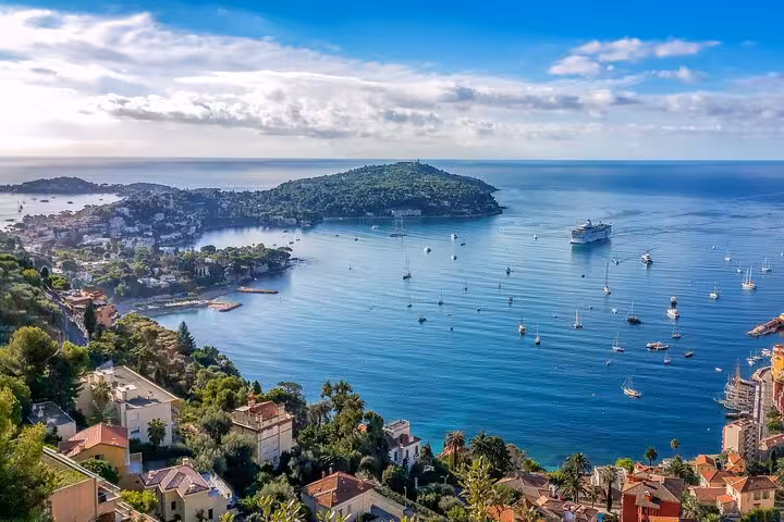 Scenic view of Villefranche-sur-Mer coast with boats on azure waters, perfect for a private tour from Nice to Monaco.