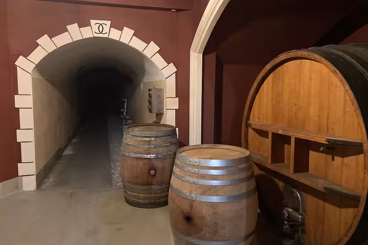 Wine cellar with wooden barrels and arched stone entrance on Villefranche sur Mer private wine tasting tour.