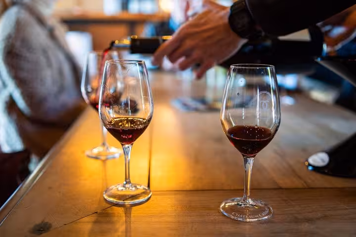 Elegant wine tasting with red wine glasses on a wooden table in a Villefranche sur Mer private tour setting.