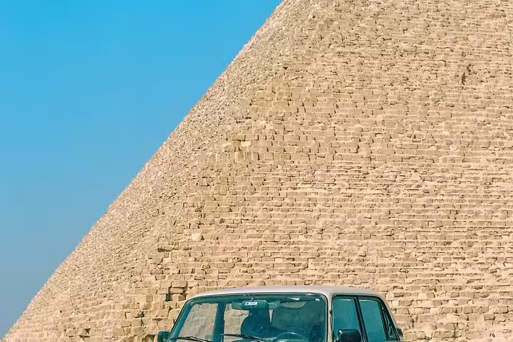 Vintage car by the Great Pyramid of Giza, Egypt, on a royal expedition tour to Giza, Saqqara and Dahshur