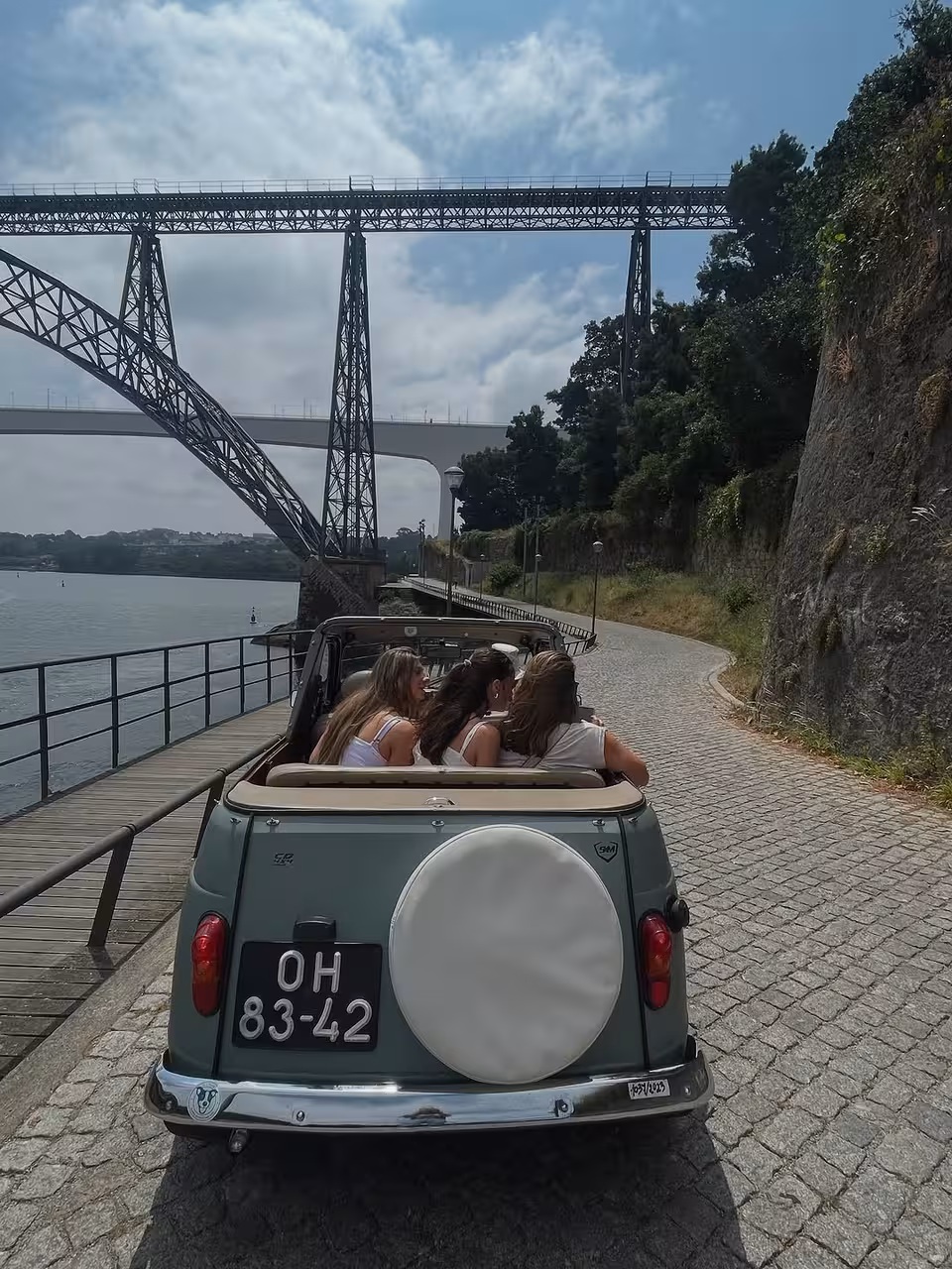 Vintage convertible on Porto North Coast tour by the Douro River with Dom Luís I Bridge views