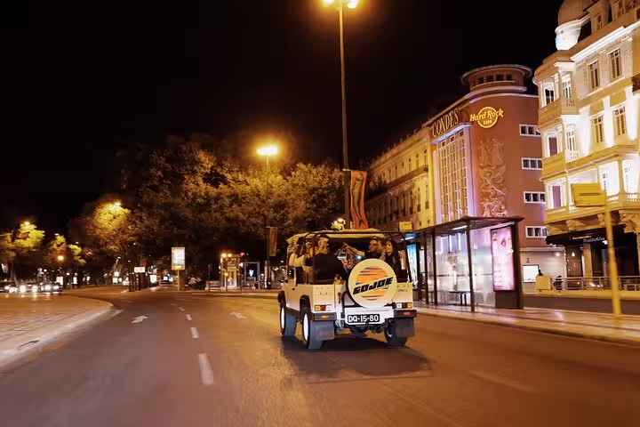 Vintage Jeep Lisbon night tour cruising illuminated Avenida da Liberdade with local food and drink tasting